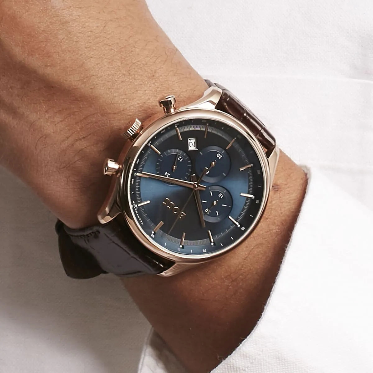 Hugo Boss Gregor chronograph watch worn on male wrist showing blue dial and rose gold case
