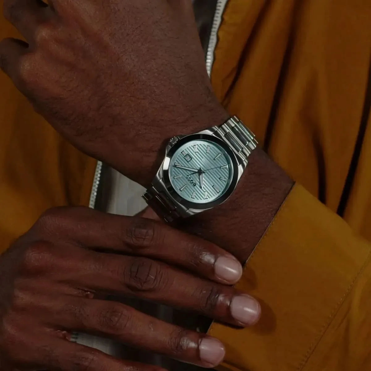 Hugo Boss Strike casual men's watch on wrist showing turquoise dial and silver bracelet