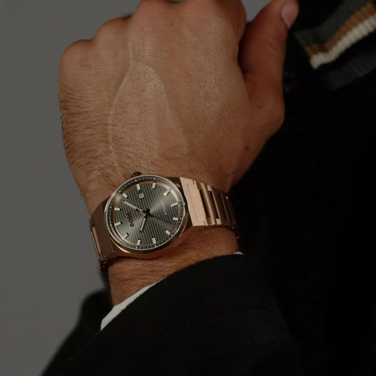 Hugo Boss Candor automatic watch worn on wrist showing rose gold bracelet and grey dial