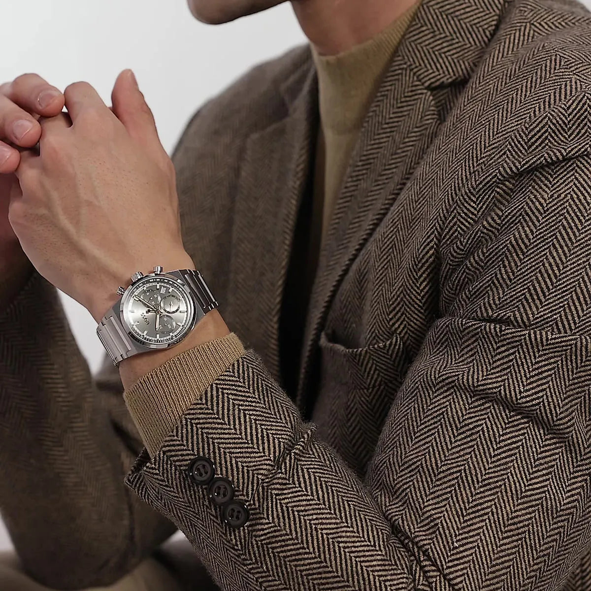 Hugo Boss Candor watch worn on wrist with beige textured jacket