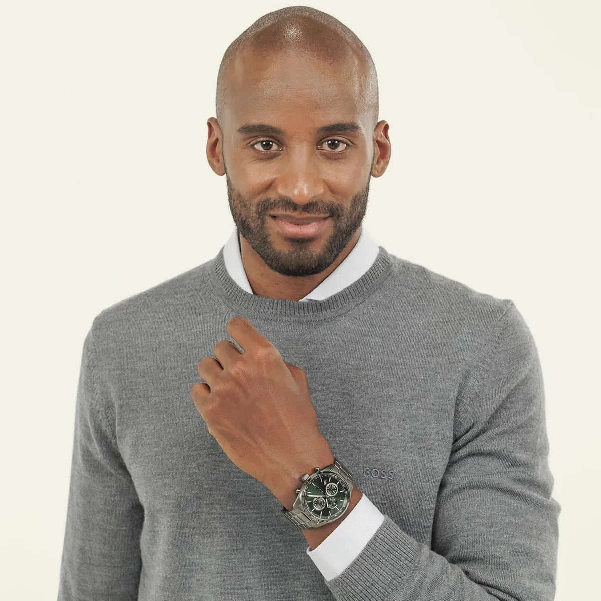 Hugo Boss Grand Prix chronograph watch worn on wrist showing green dial in casual setting
