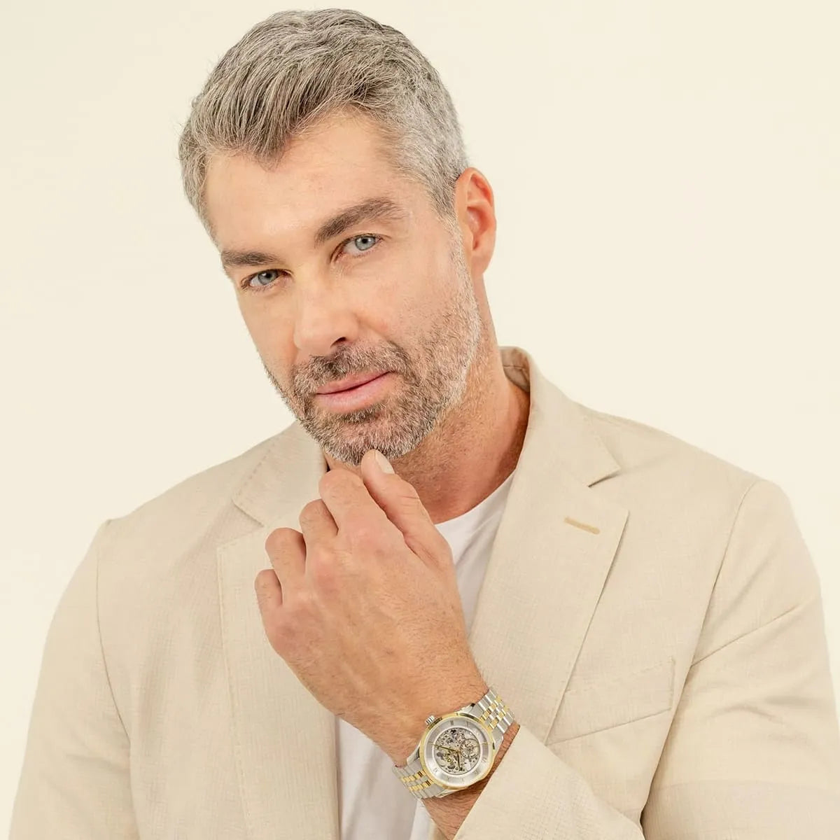 Hugo Boss Principle skeleton watch worn on man's wrist with tan jacket