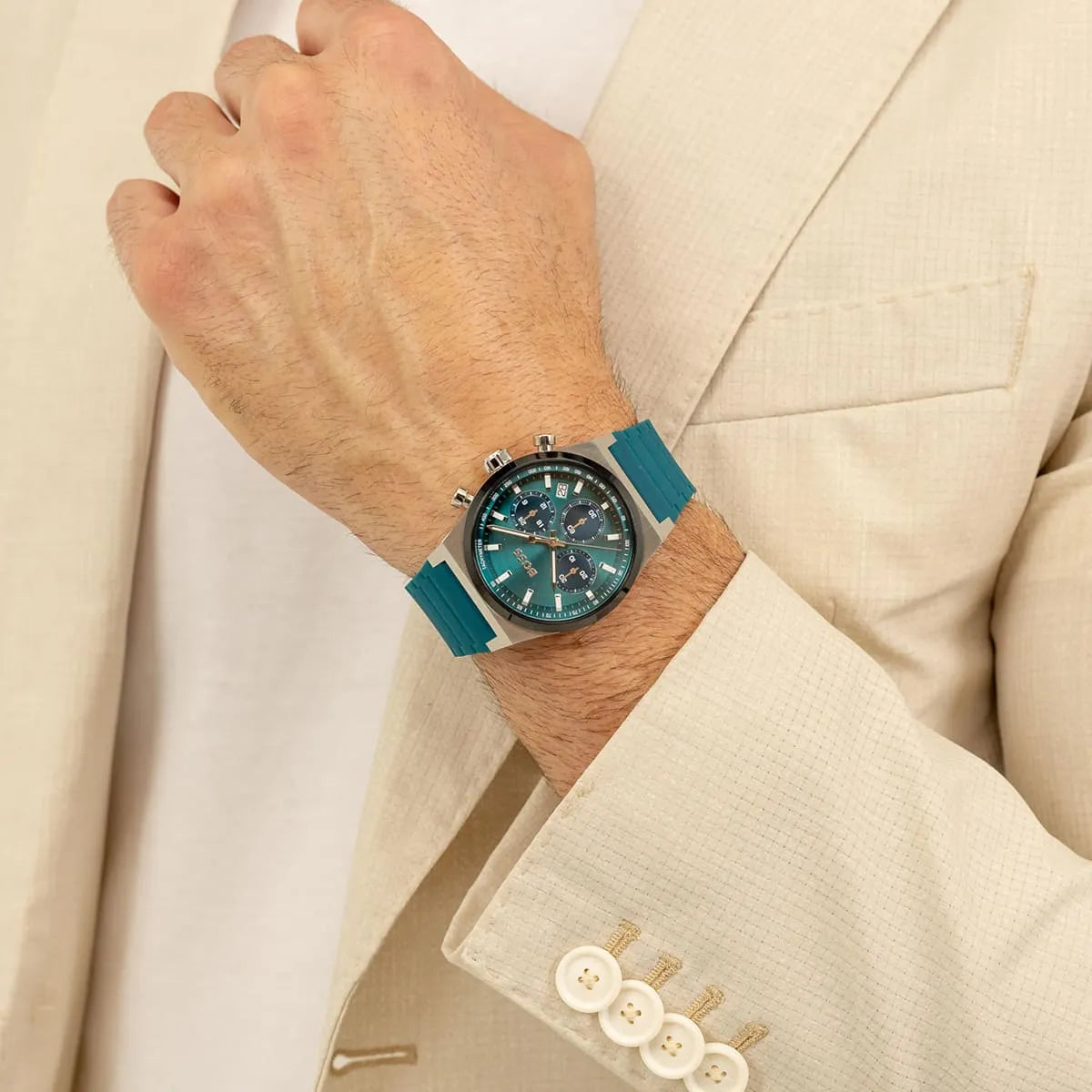 Hugo Boss green chronograph watch worn on wrist with cream suit