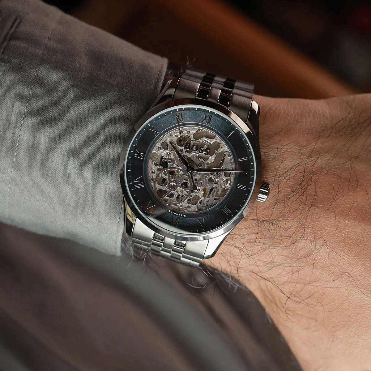 Hugo Boss Principle skeleton watch worn on wrist displaying blue bezel and steel band