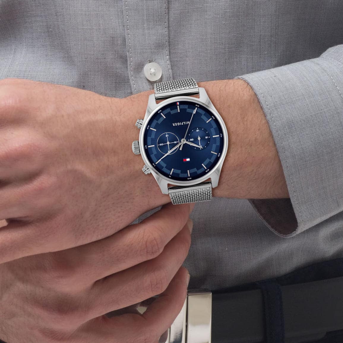 Tommy Hilfiger men's chronograph watch on wrist with mesh strap and blue face