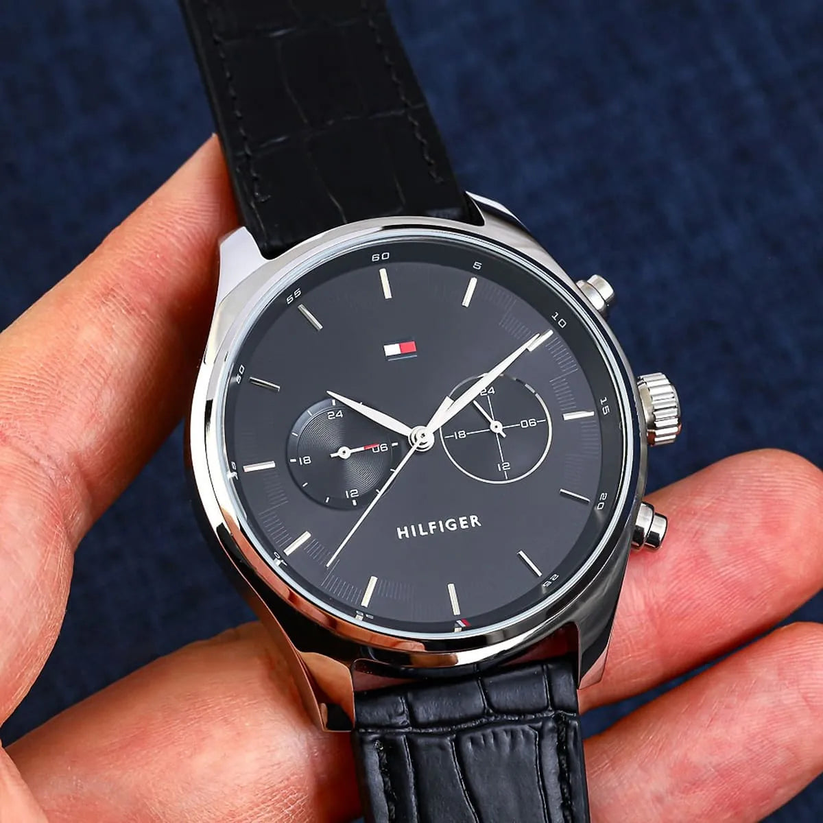Tommy Hilfiger watch displayed on wrist showing black dial and leather strap detail