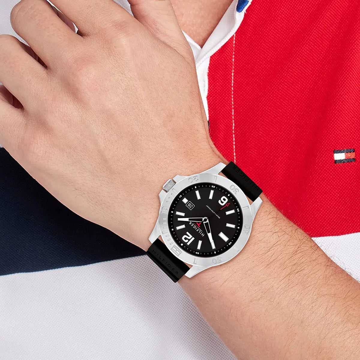 Tommy Hilfiger Ryan watch on wrist with red and navy clothing detail