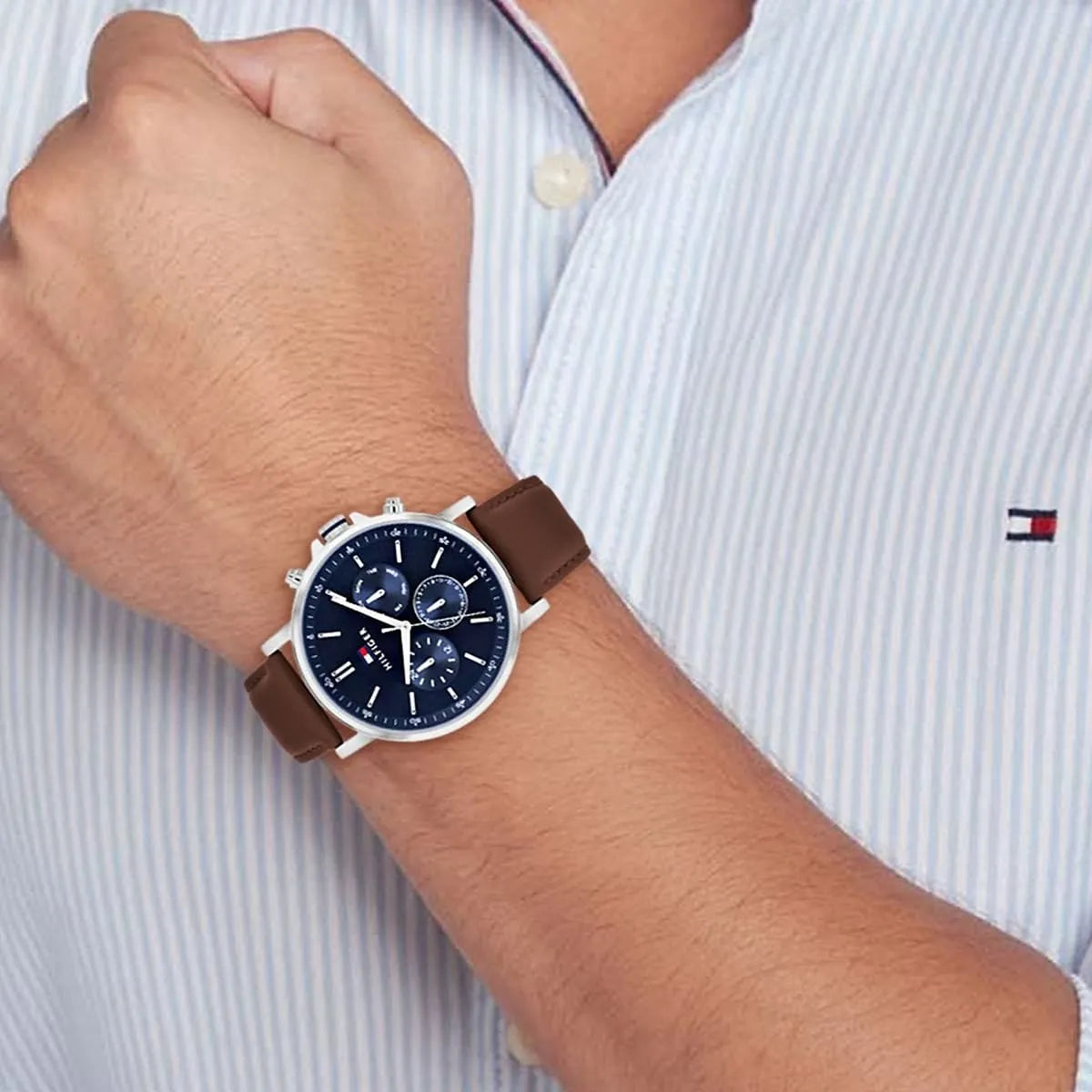 Tyson chronograph watch on wrist with blue dial and brown strap against light striped shirt
