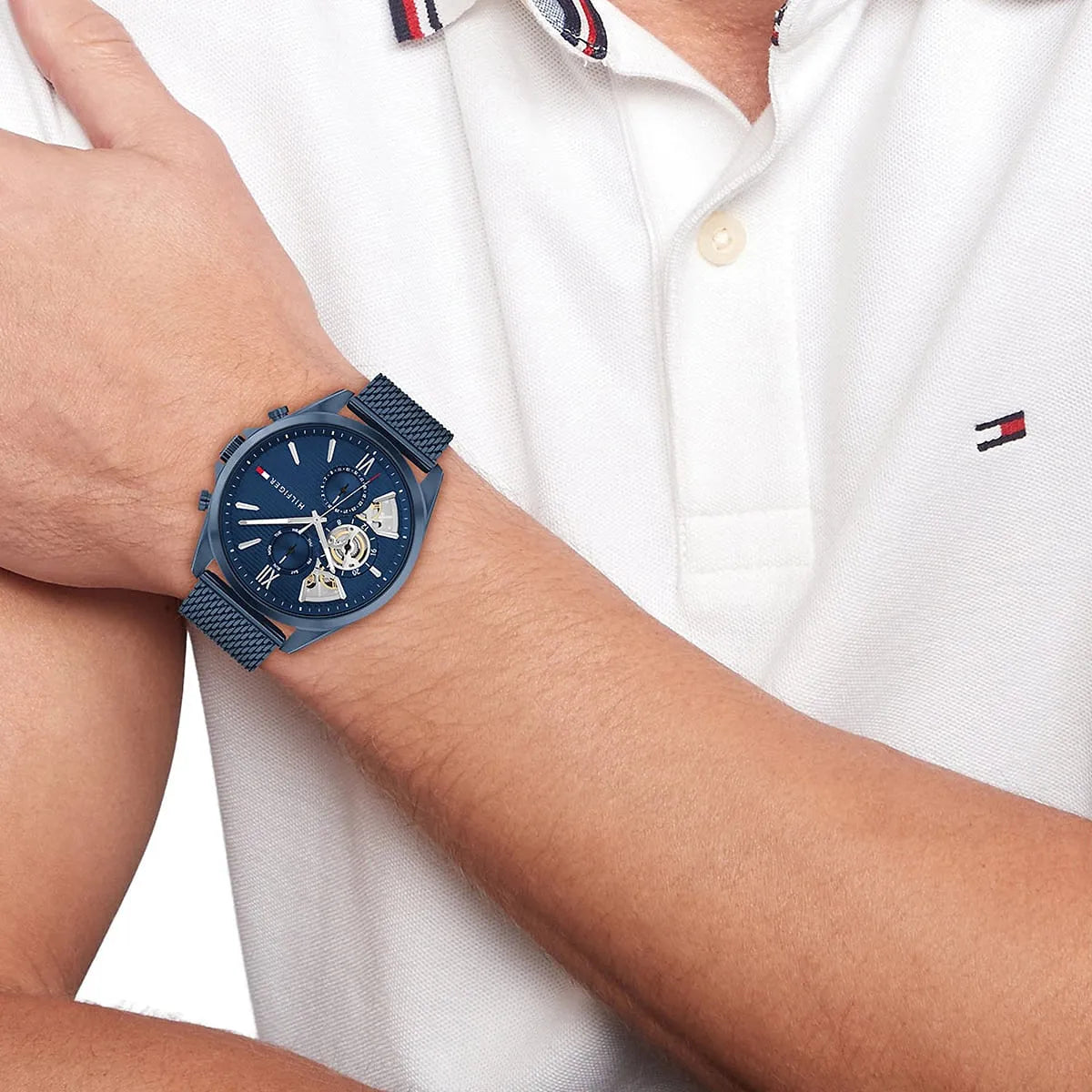 Tommy Hilfiger blue multifunction watch worn on wrist with white shirt