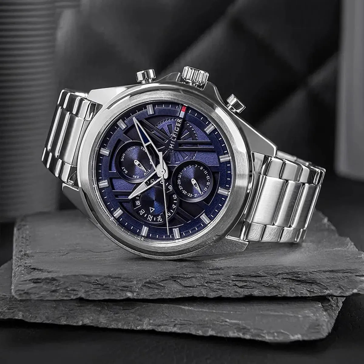 Tommy Hilfiger stainless steel chronograph watch with navy blue dial and subdials, artistic view
