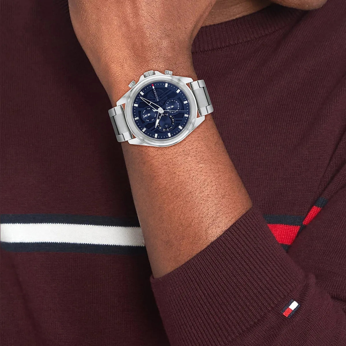 Tommy Hilfiger navy chronograph watch worn on wrist with stainless steel bracelet