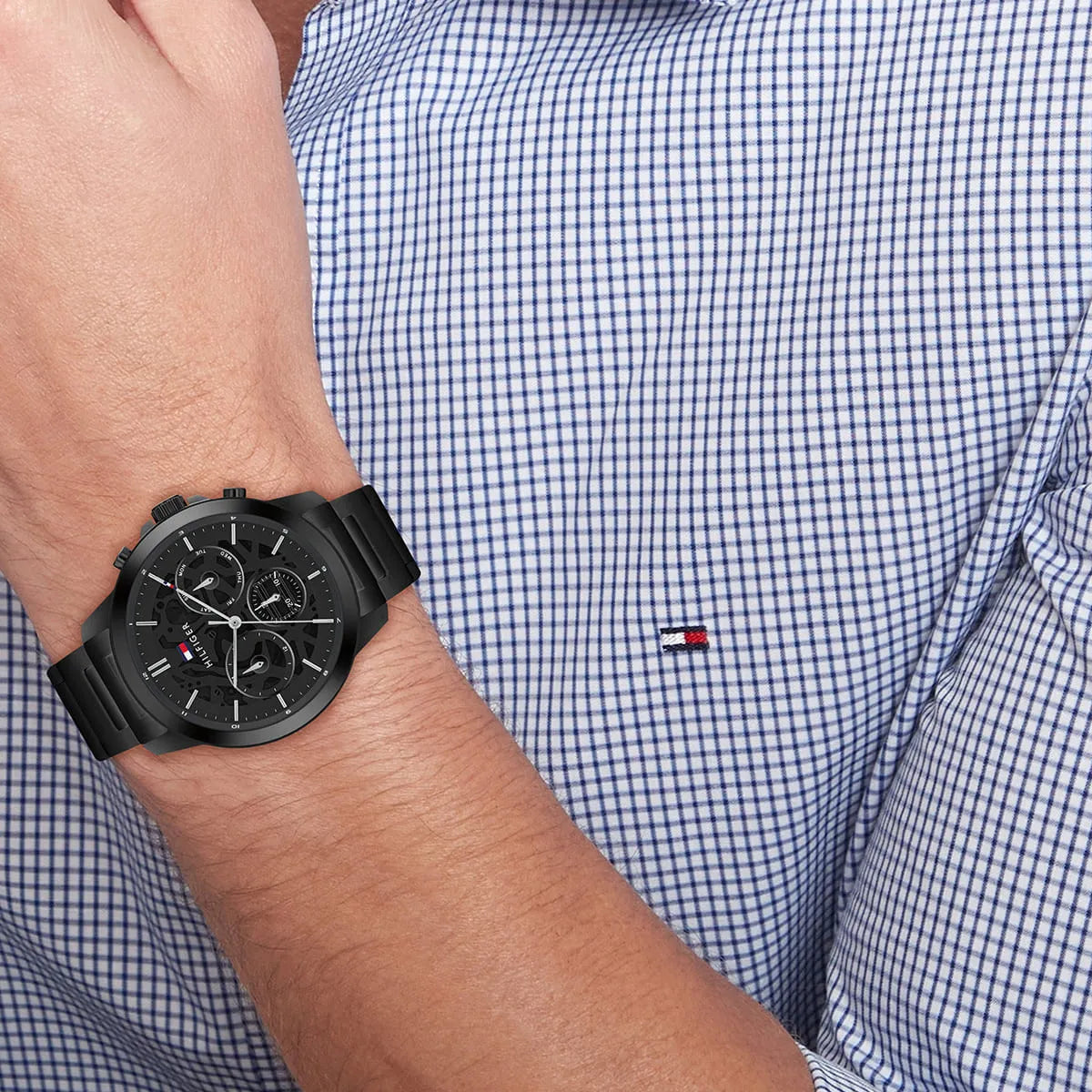 Tommy Hilfiger black chronograph watch worn on wrist showing steel bracelet side view