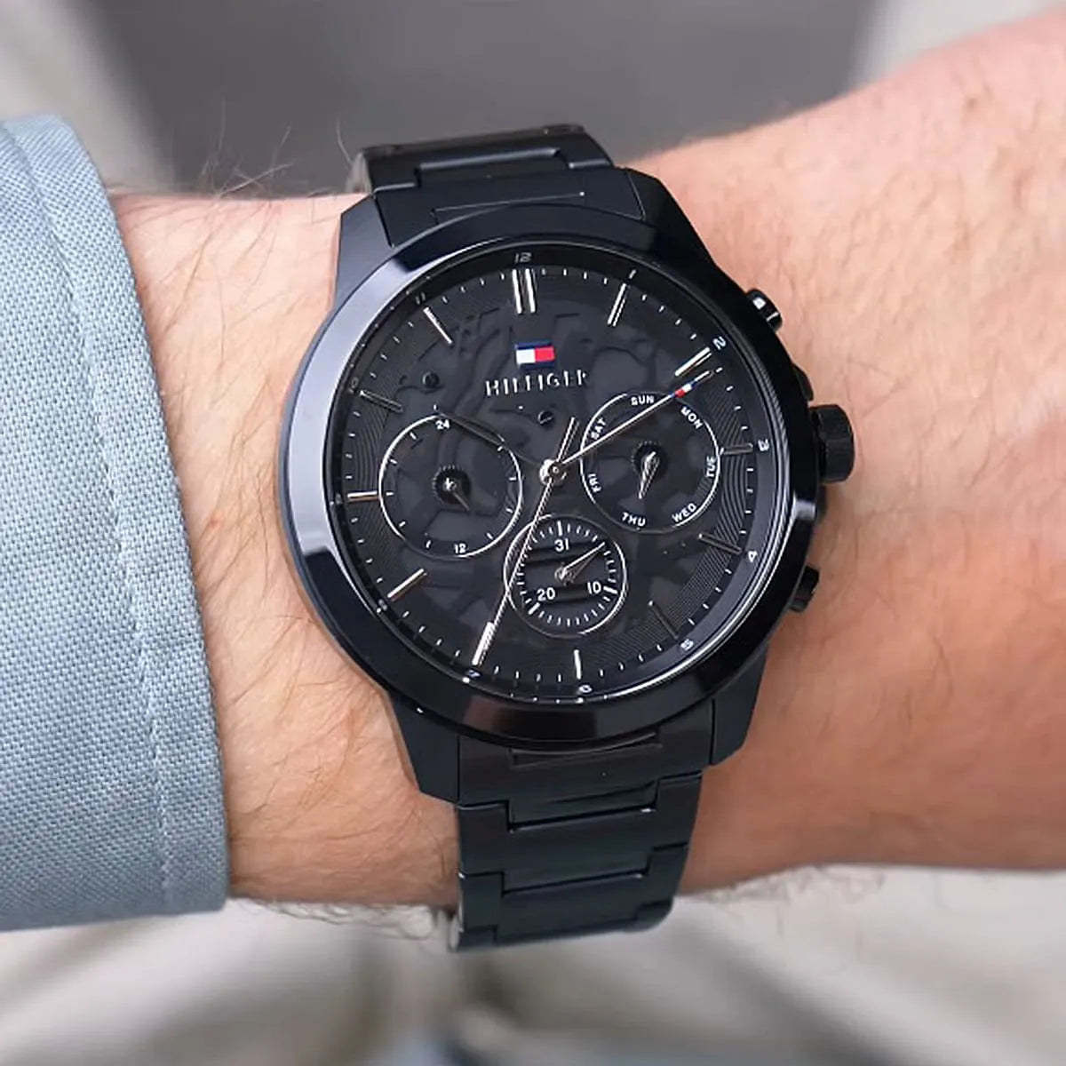 Tommy Hilfiger black chronograph watch worn on wrist with black steel bracelet