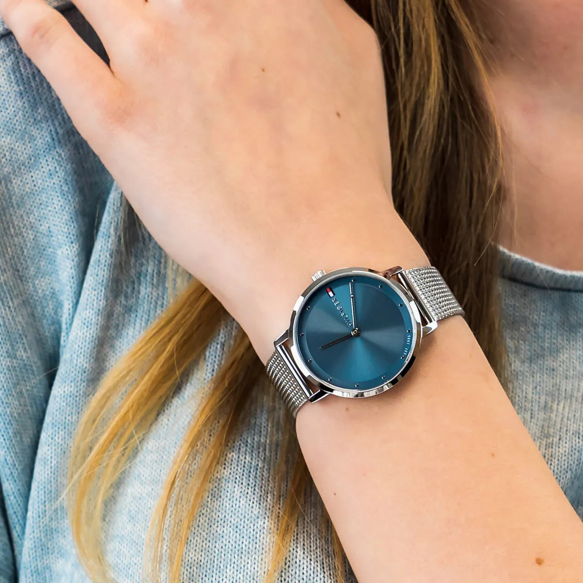 Tommy Hilfiger Pippa watch on wrist detail showing blue sunburst dial and mesh strap
