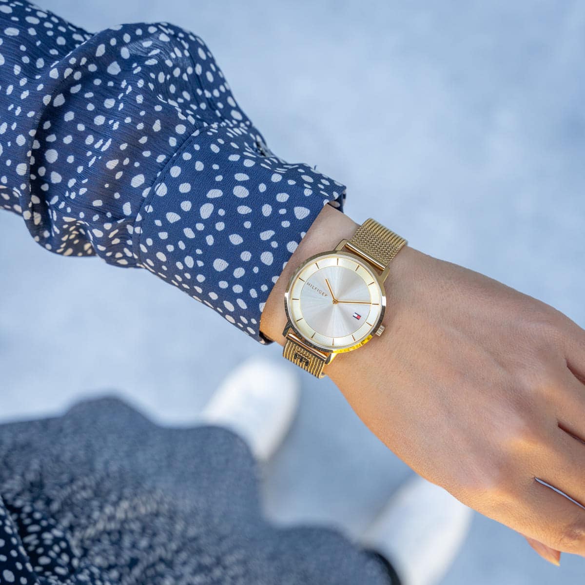 Tommy Hilfiger 1782286 women's watch on wrist with gold mesh strap and cream dial