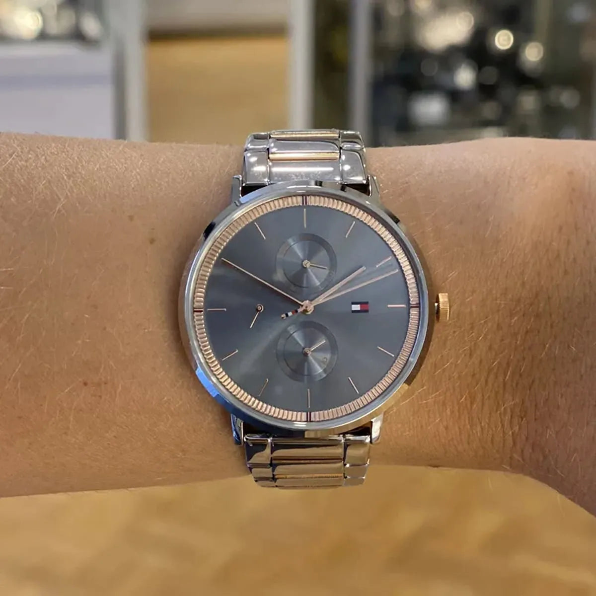 Tommy Hilfiger Jenna women's watch worn on wrist showing blue dial and silver rose gold bracelet