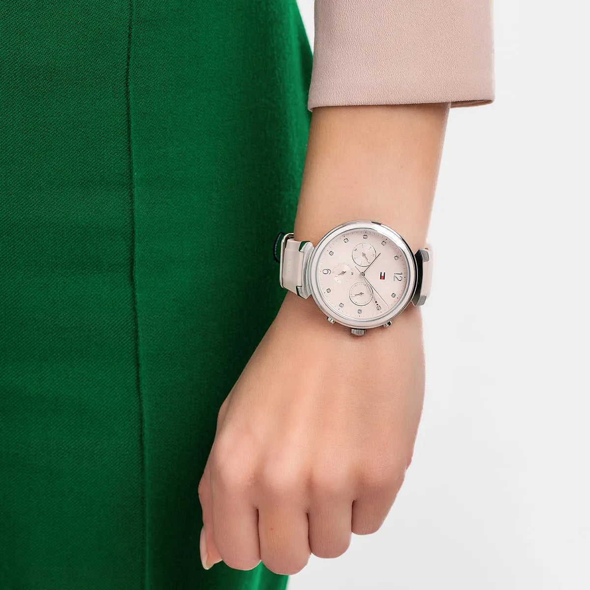 Tommy Hilfiger watch on wrist with pink dial and rubber strap on model