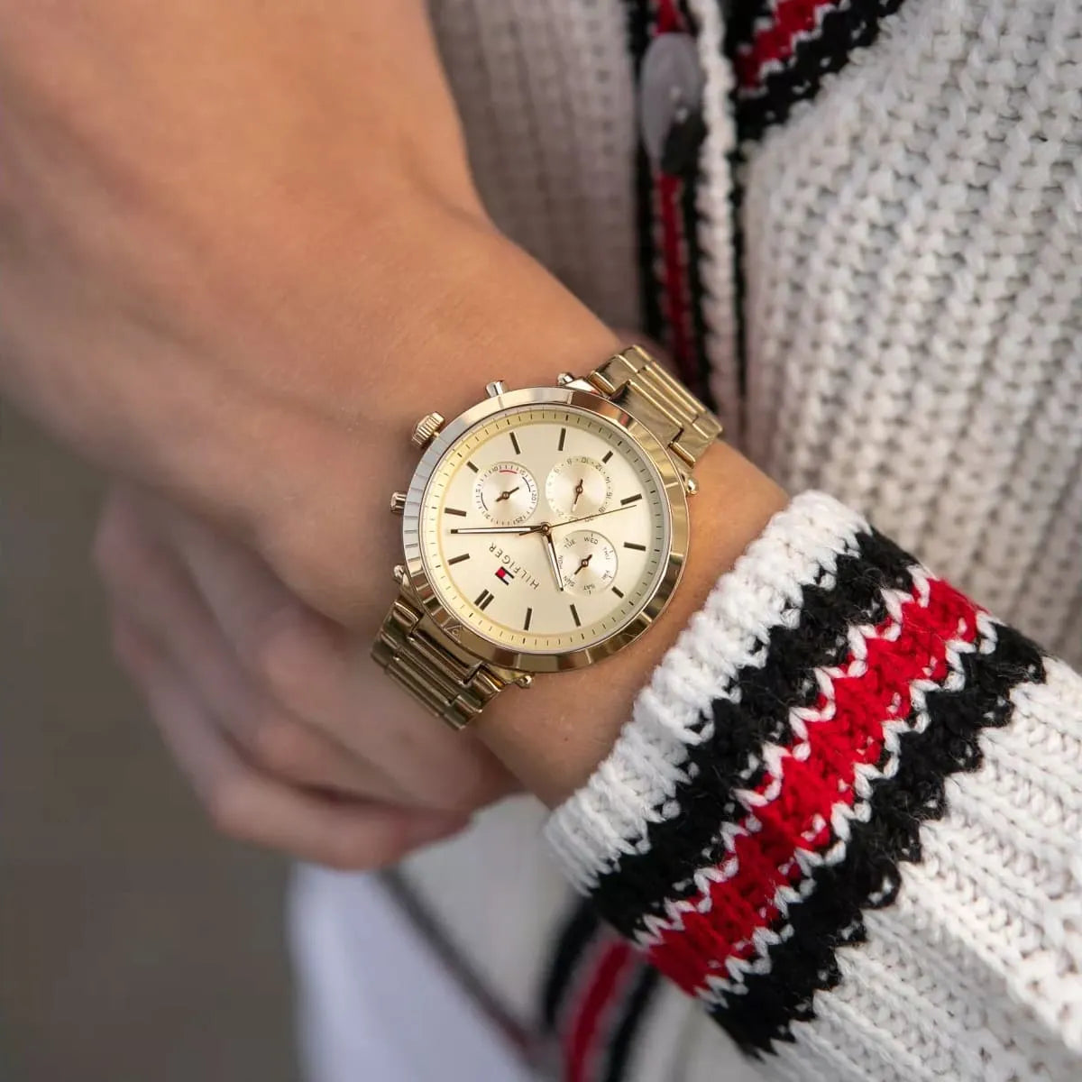 Tommy Hilfiger Emery gold multi-function watch worn on wrist over sweater
