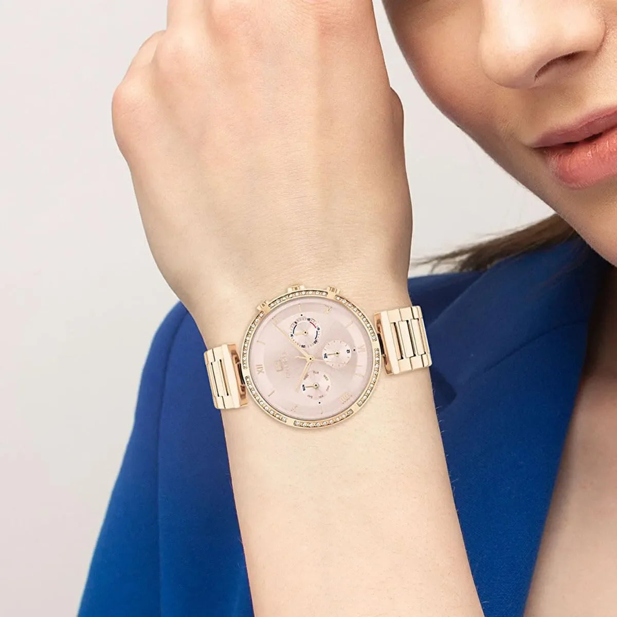 Tommy Hilfiger rose gold women's watch on wrist with chronograph subdials and stone-set bezel