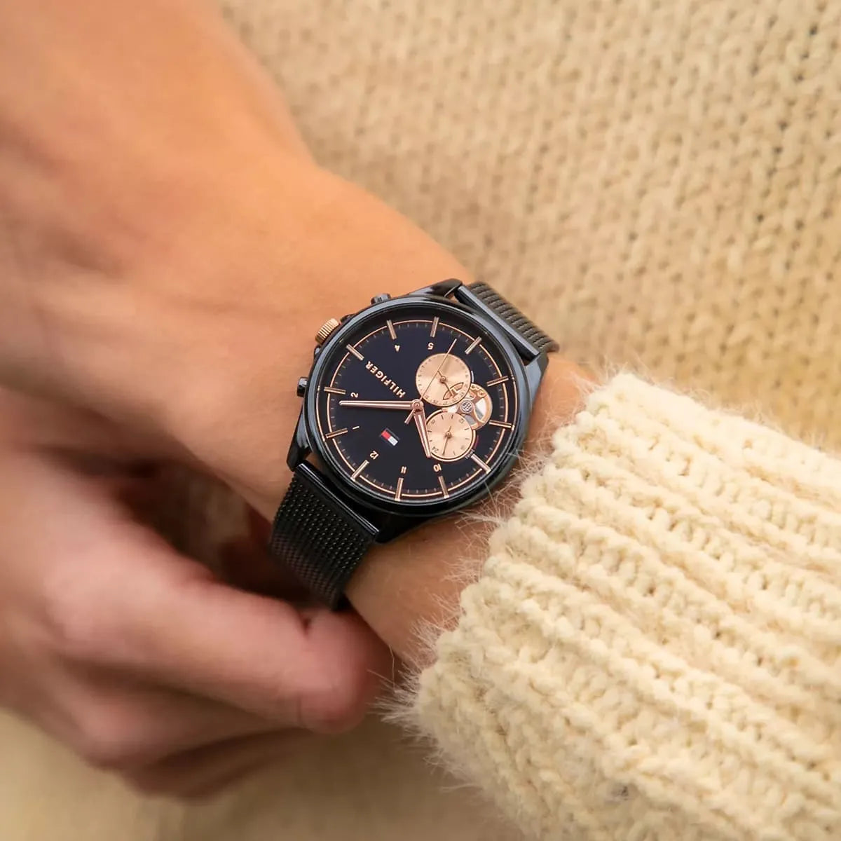 Tommy Hilfiger women's watch worn on wrist with navy mesh strap and blue dial