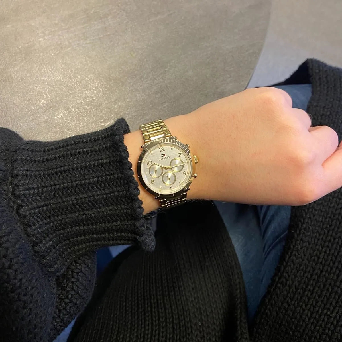 Tommy Hilfiger Emery chronograph watch on wrist showing gold case, white dial and three subdials