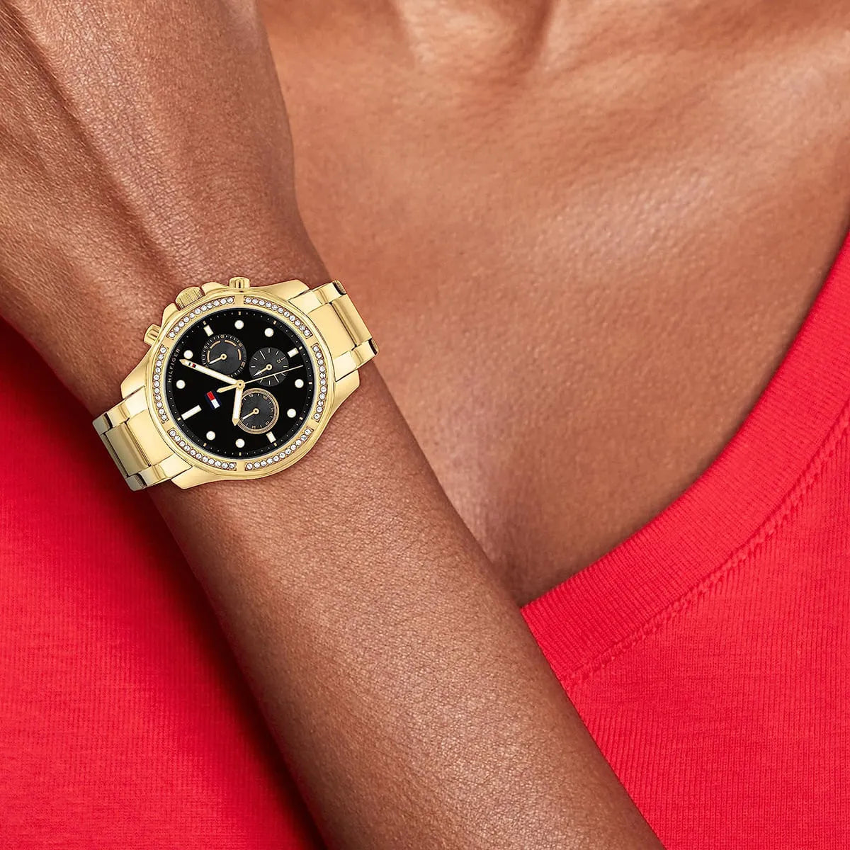 Tommy Hilfiger Libby women's chronograph watch on wrist with red sleeve showing black dial and crystals
