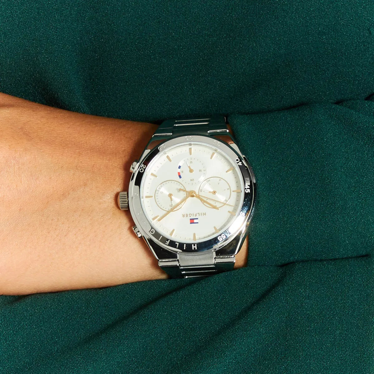 Tommy Hilfiger Libby chronograph watch worn on wrist with green fabric background