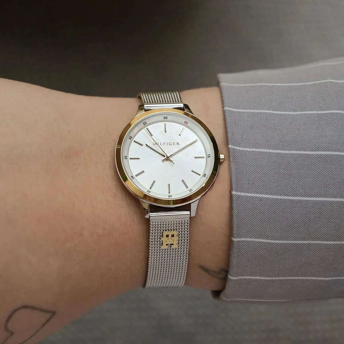 Tommy Hilfiger Iris watch worn on wrist showing white dial and mesh strap