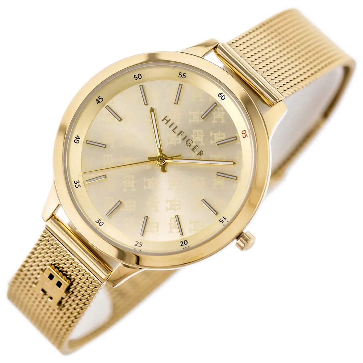 Tommy Hilfiger gold watch on wrist with mesh strap and light champagne dial