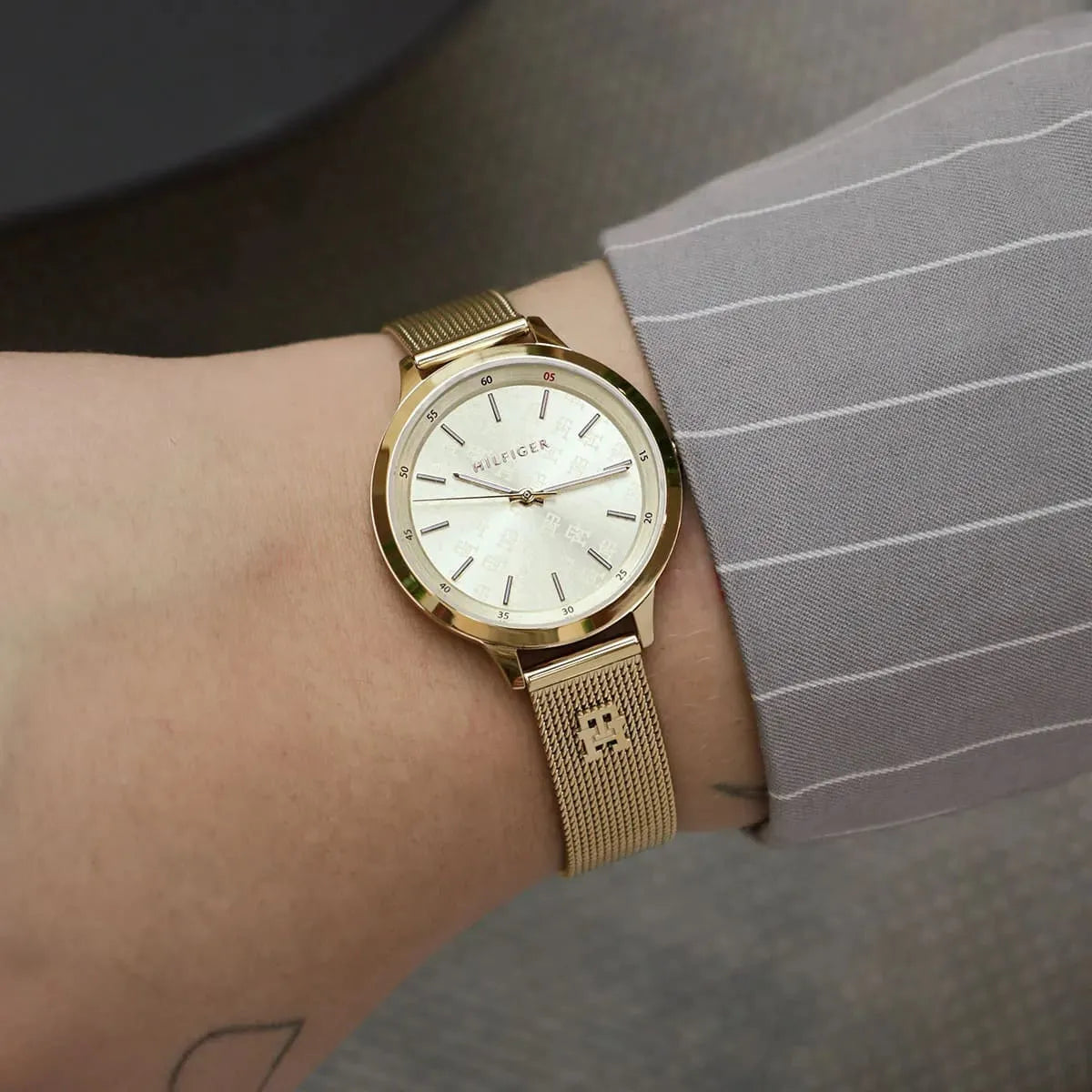 Tommy Hilfiger gold mesh watch on wrist showing cream dial and elegant slim design