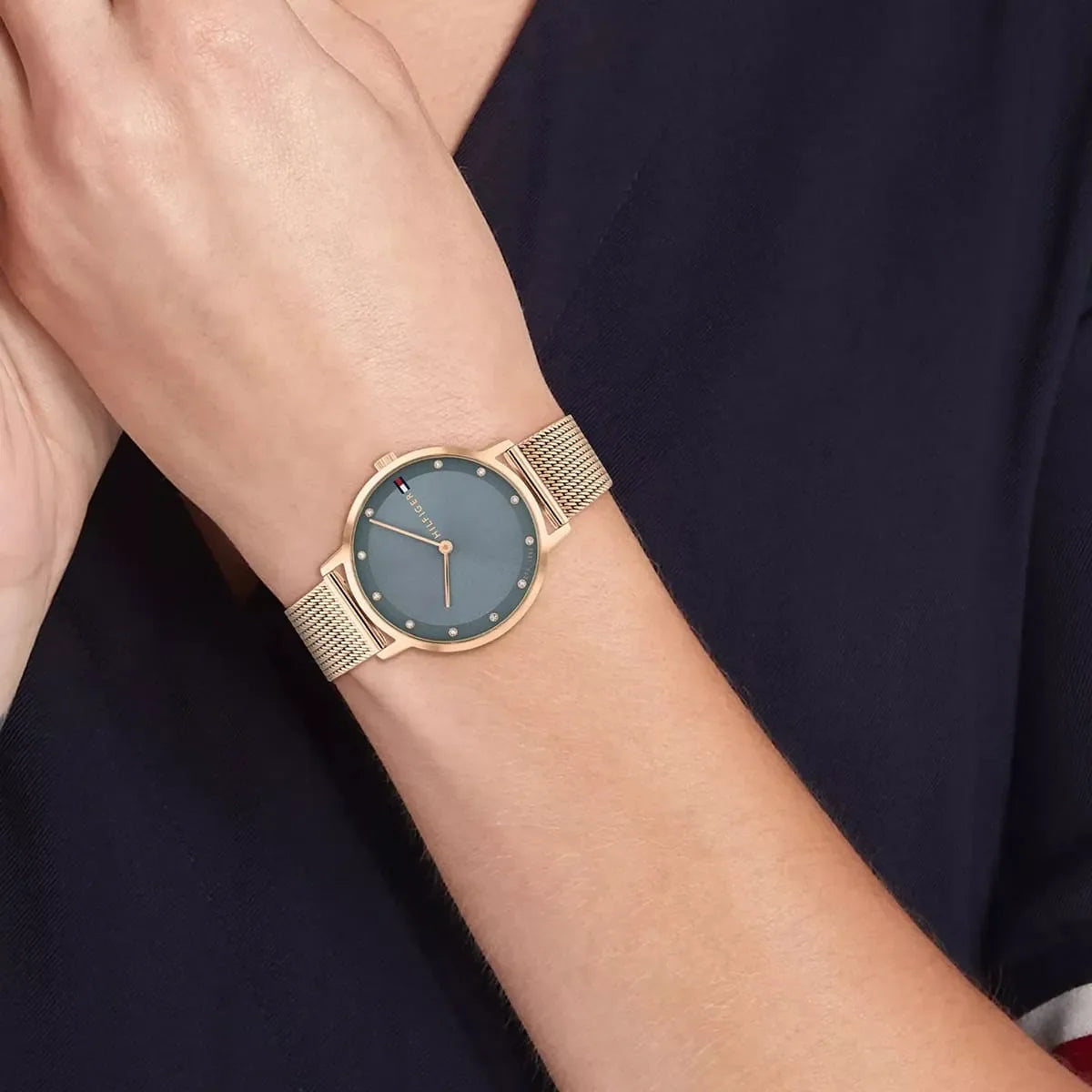 Tommy Hilfiger women's watch worn on wrist, rose gold case with blue dial and Milanese strap