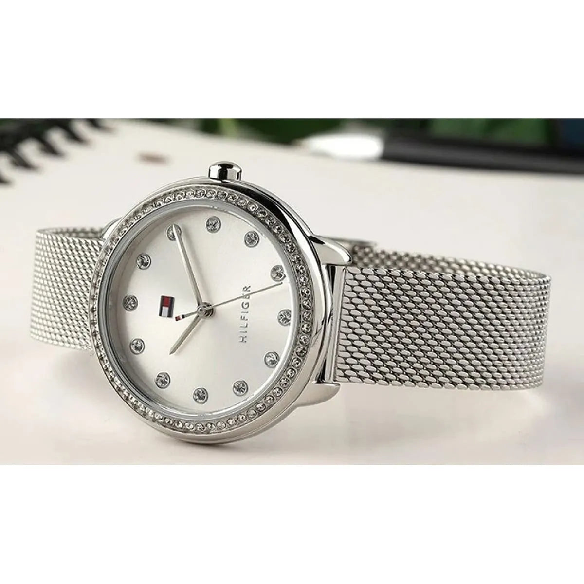 Overhead product shot of Tommy Hilfiger silver women's watch with mesh bracelet