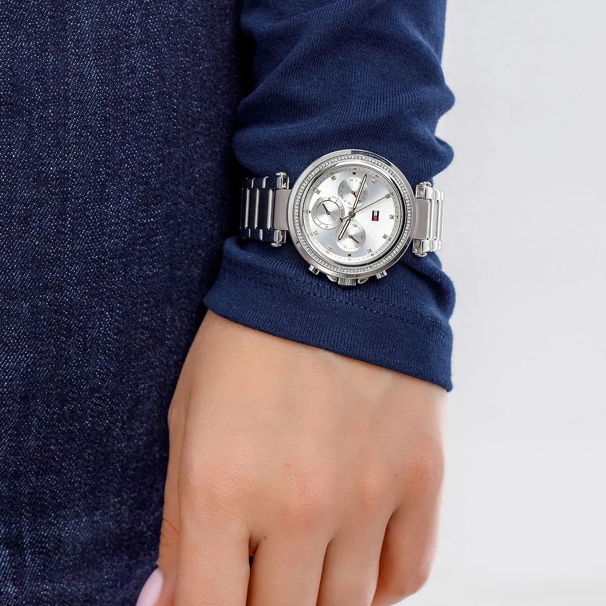 Tommy Hilfiger women's chronograph watch worn on wrist with silver dial and crystal bezel