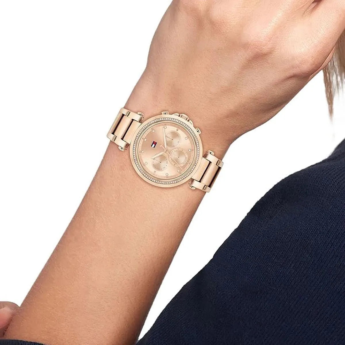 Rose gold multifunction watch on wrist displaying crystal-set bezel and chronograph
