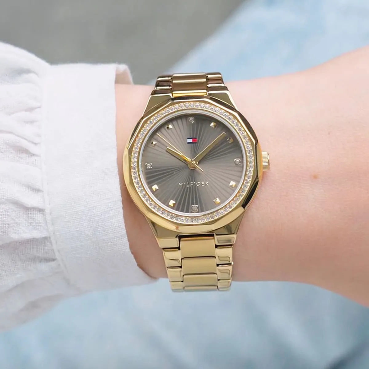 Tommy Hilfiger gold watch on wrist showing dial detail and gold bracelet