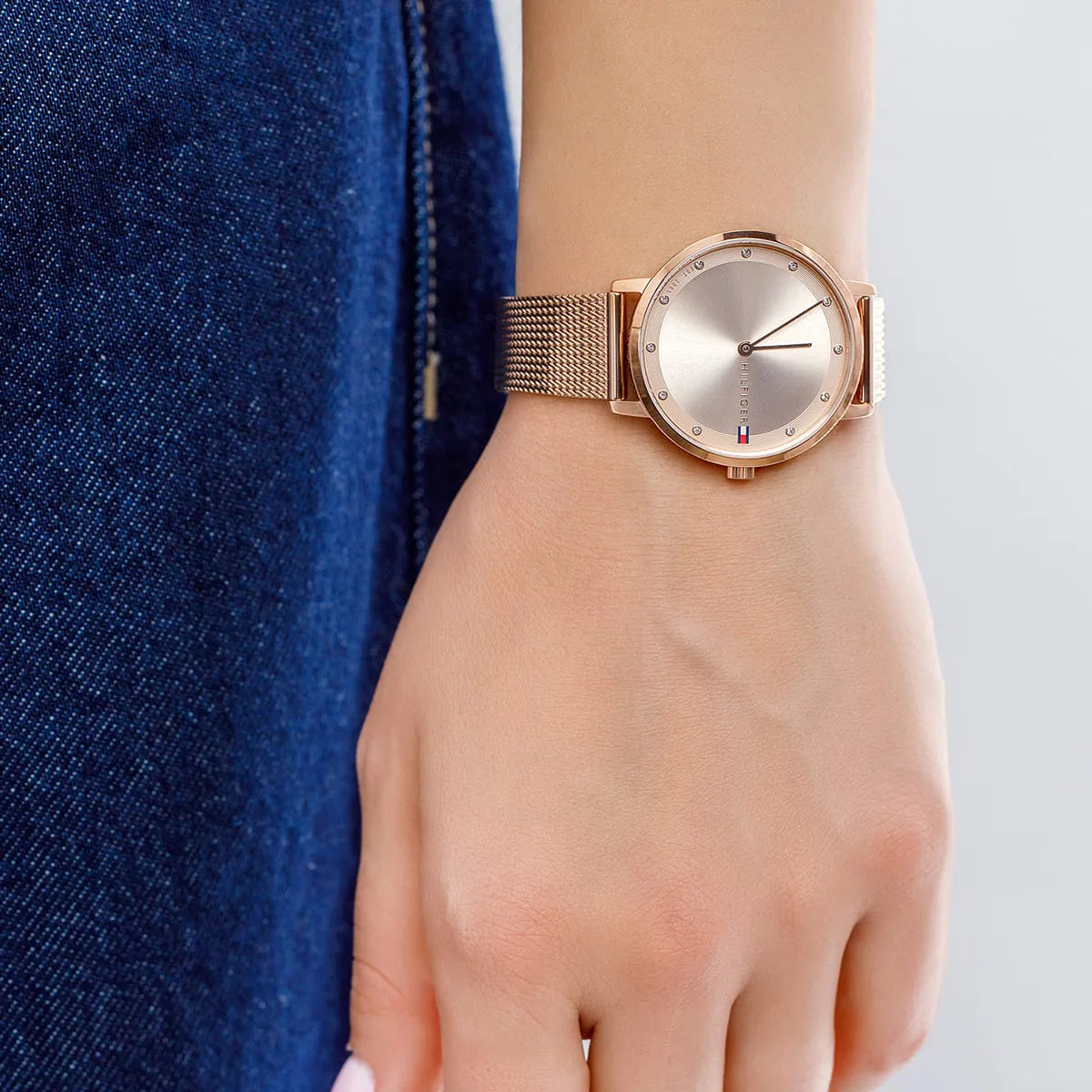 Tommy Hilfiger Pippa rose gold watch worn on wrist with blue shirt sleeve