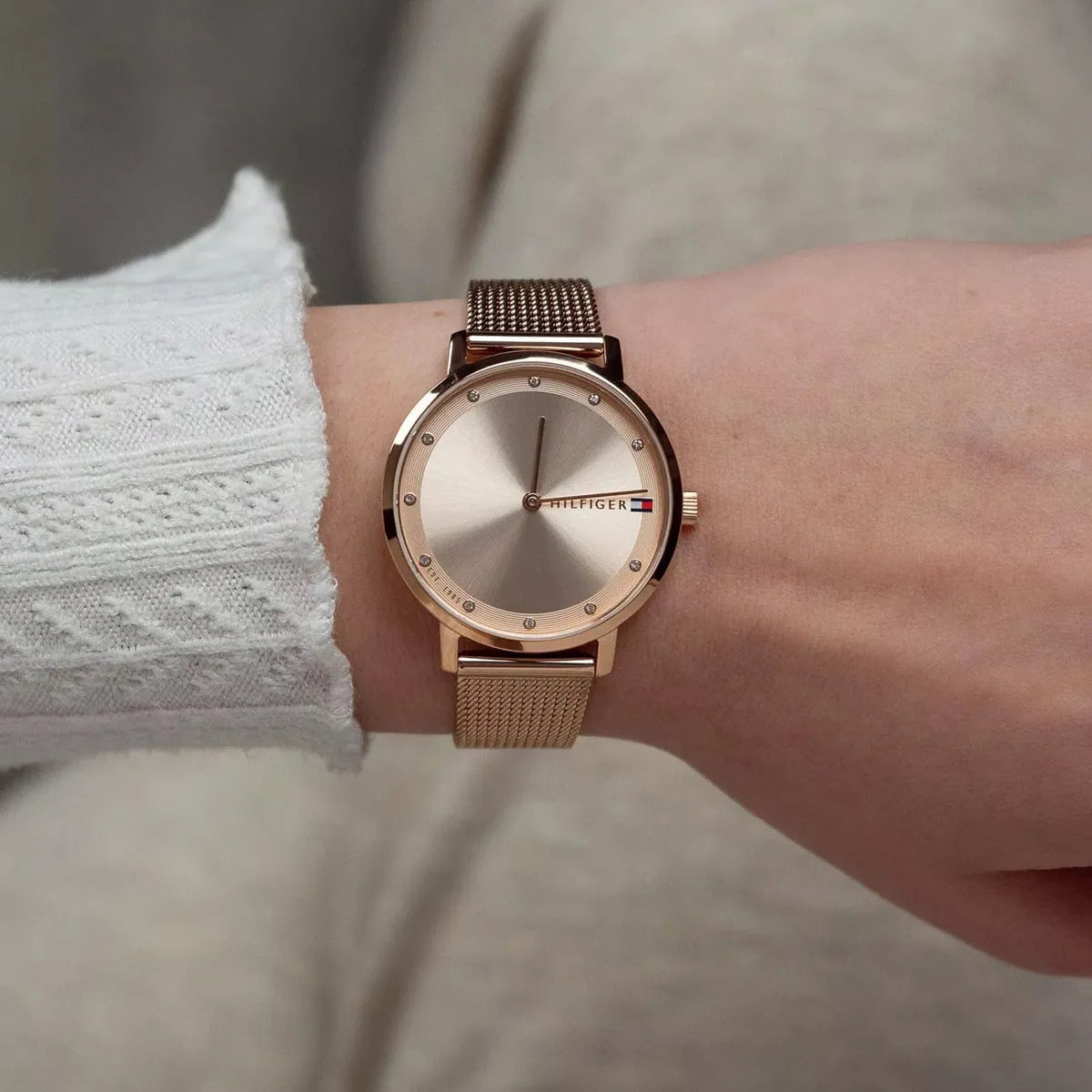 Tommy Hilfiger Pippa rose gold mesh watch worn on wrist with white sweater
