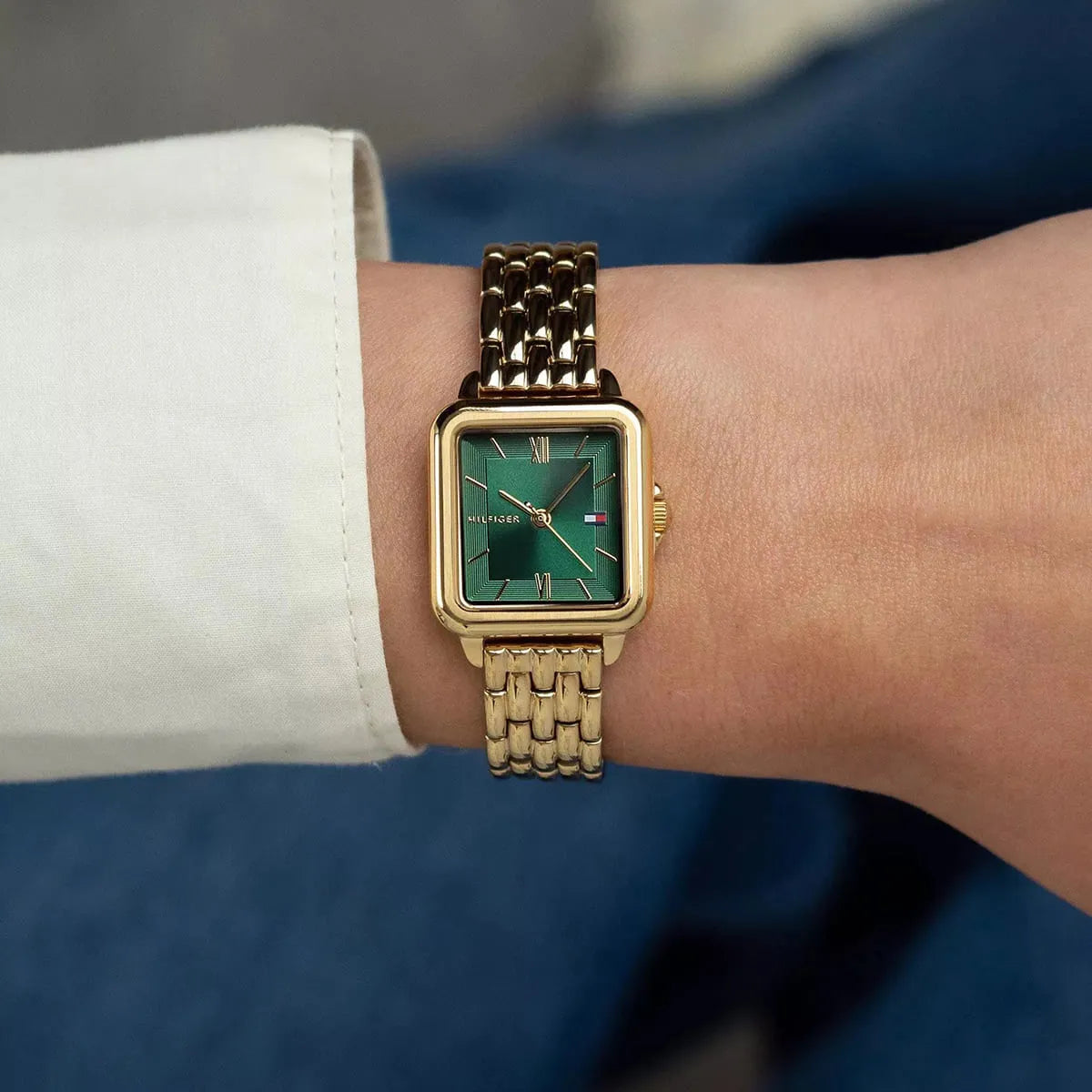 Tommy Hilfiger Mia gold watch worn on wrist with green square dial visible