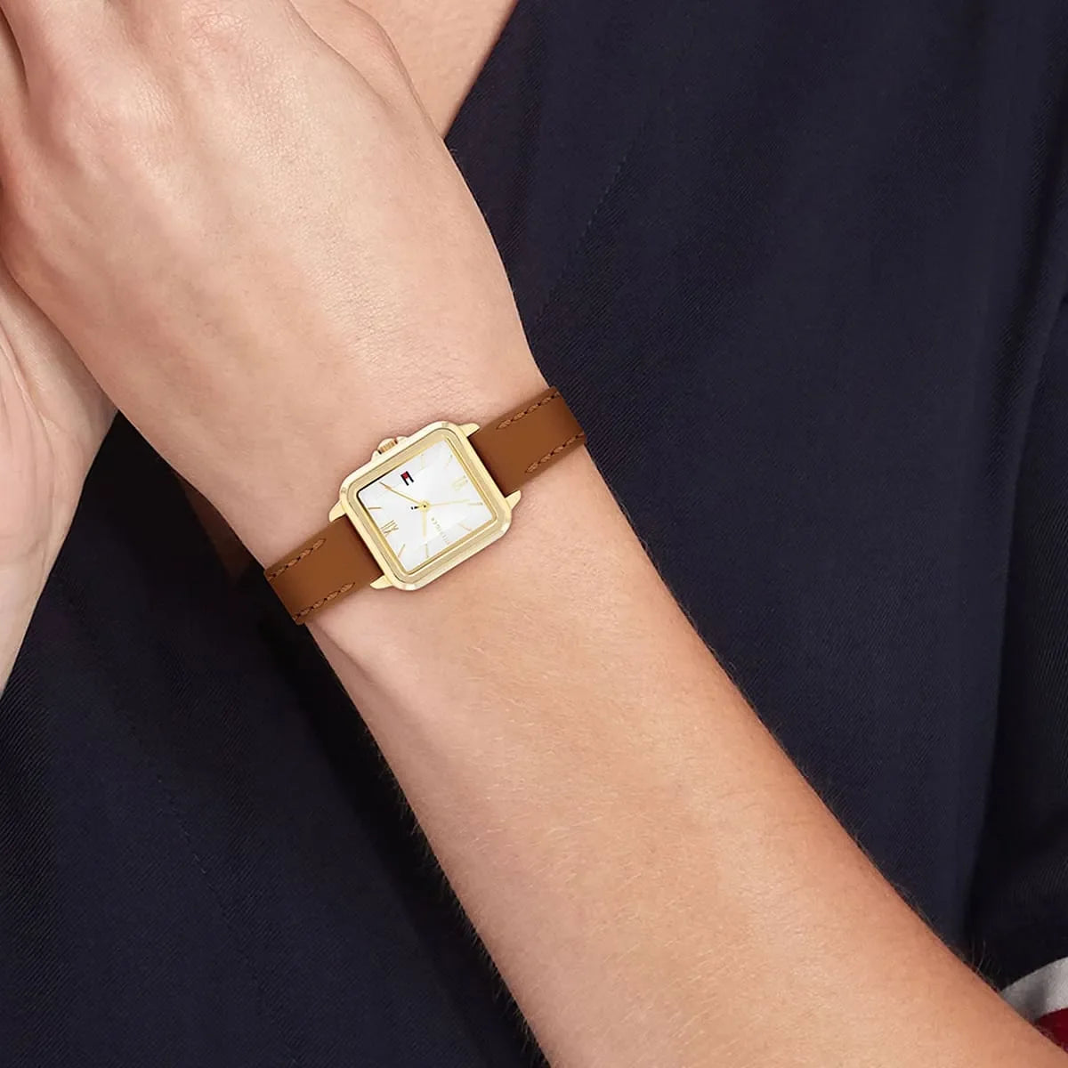Tommy Hilfiger Mia watch worn on wrist showing square gold case and white dial