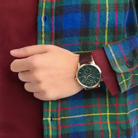 Tommy Hilfiger 1791607 watch worn on wrist with green dial and brown leather strap