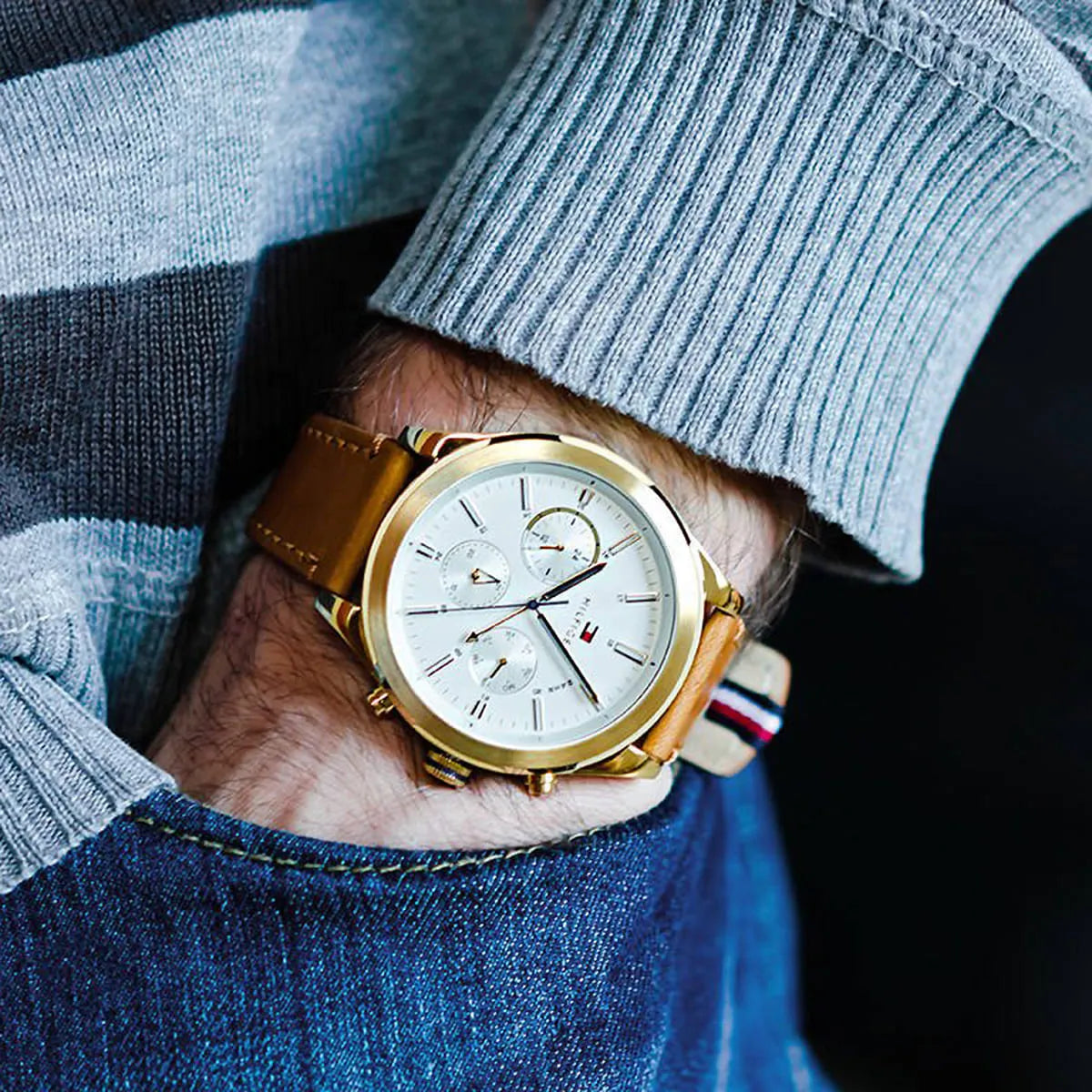 Tommy Hilfiger multifunction watch on wrist with light blue striped sweater and denim