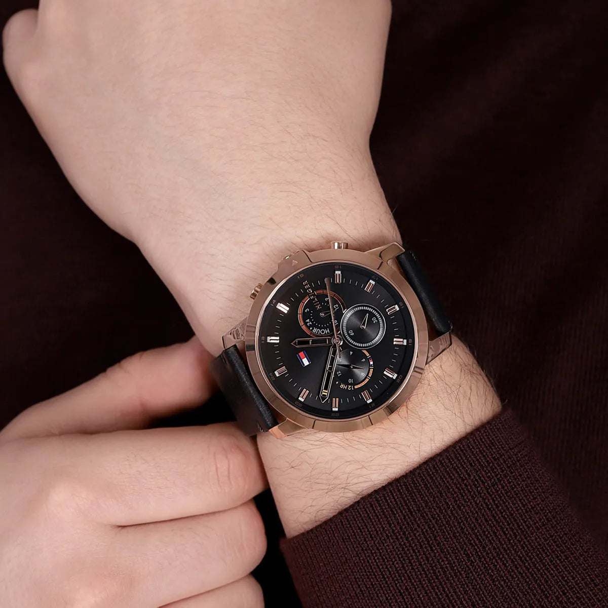 Tommy Hilfiger Jameson watch styled on-wrist showing black dial and rose gold case