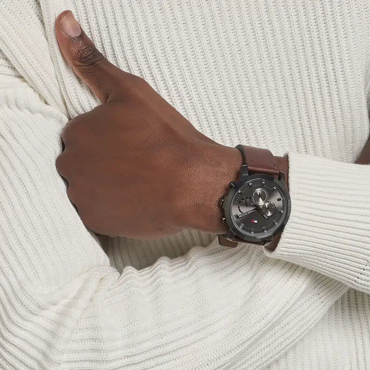 Tommy Hilfiger 1791799 watch worn on wrist against white sweater showing brown leather strap