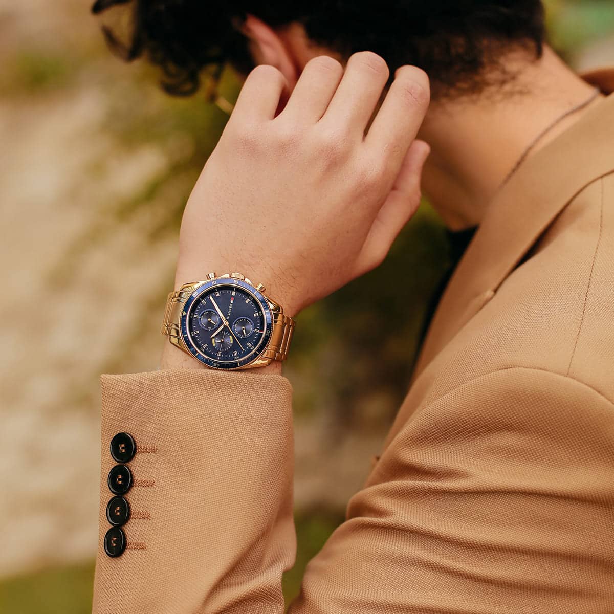 Tommy Hilfiger watch worn on wrist with navy dial and gold-tone case visible