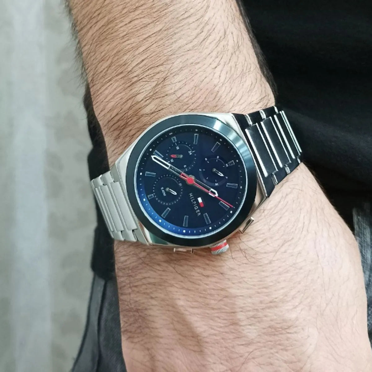 Tommy Hilfiger Connor chronograph watch worn on wrist with navy dial and silver metal band