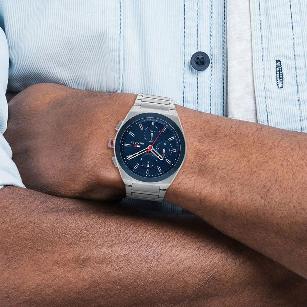 Tommy Hilfiger Connor men's watch worn on wrist with navy dial over light blue shirt