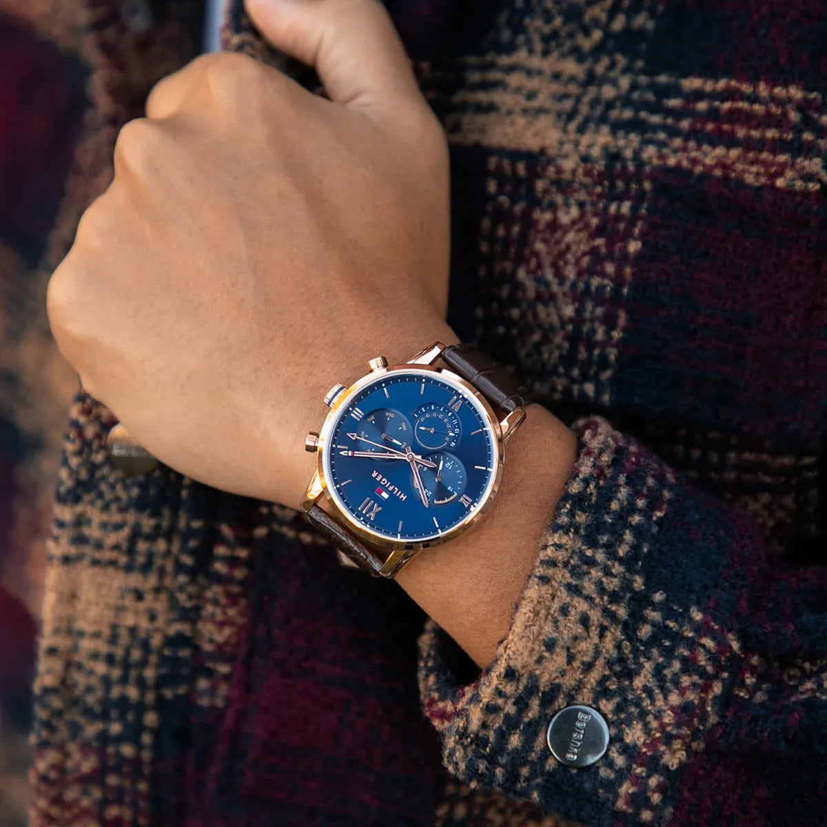 Tommy Hilfiger chronograph watch worn on wrist, displaying navy dial and rose gold case