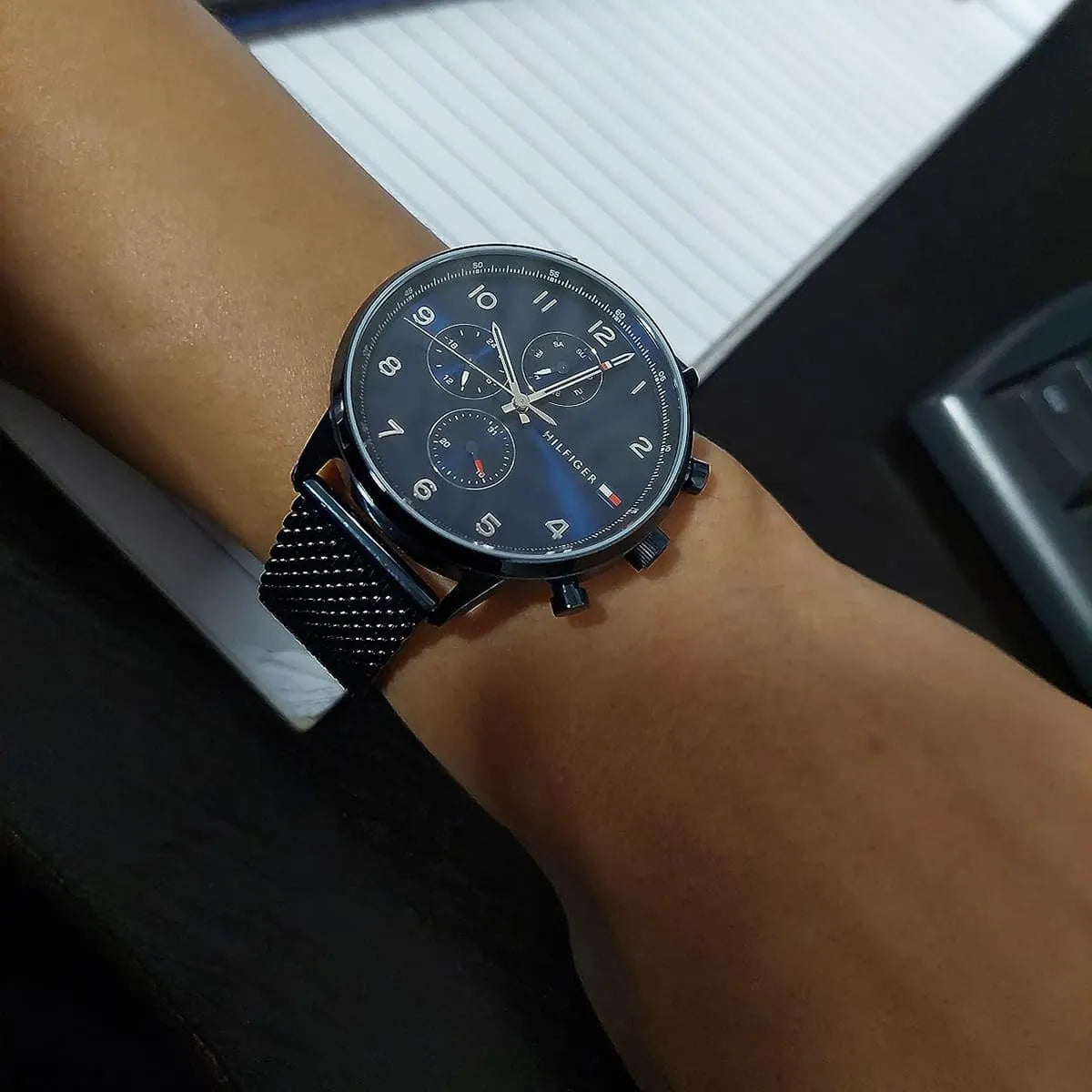 Tommy Hilfiger Leonard men's watch worn on wrist with blue dial and mesh strap