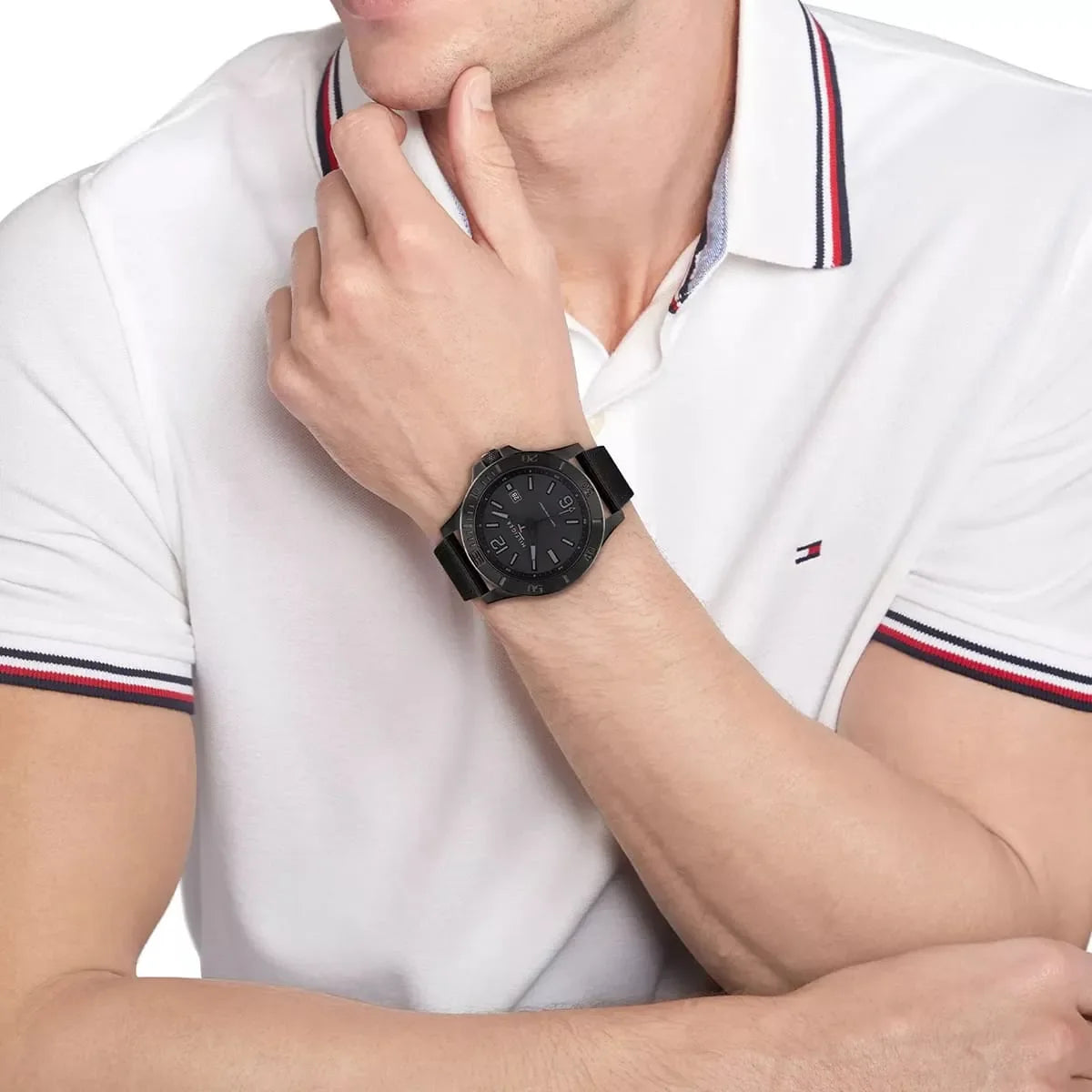 Tommy Hilfiger stainless steel watch on wrist, styled with white polo shirt