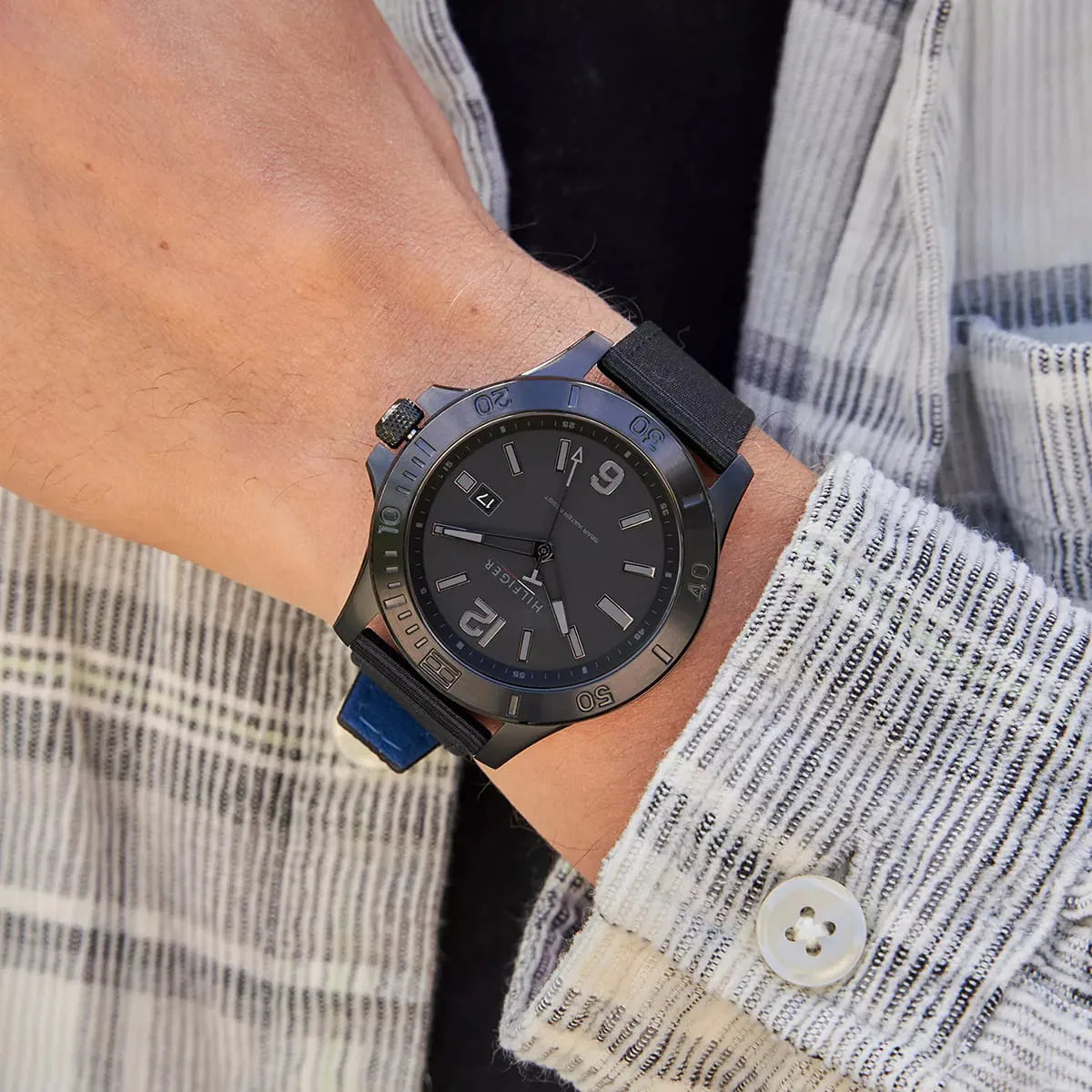 Tommy Hilfiger quartz watch worn on wrist with blue and black strap